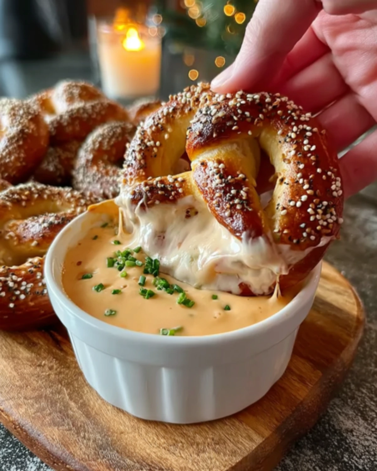 Warm Pretzel Cheese Dip with a soft salted pretzel dipped into melted cheddar and topped with chives