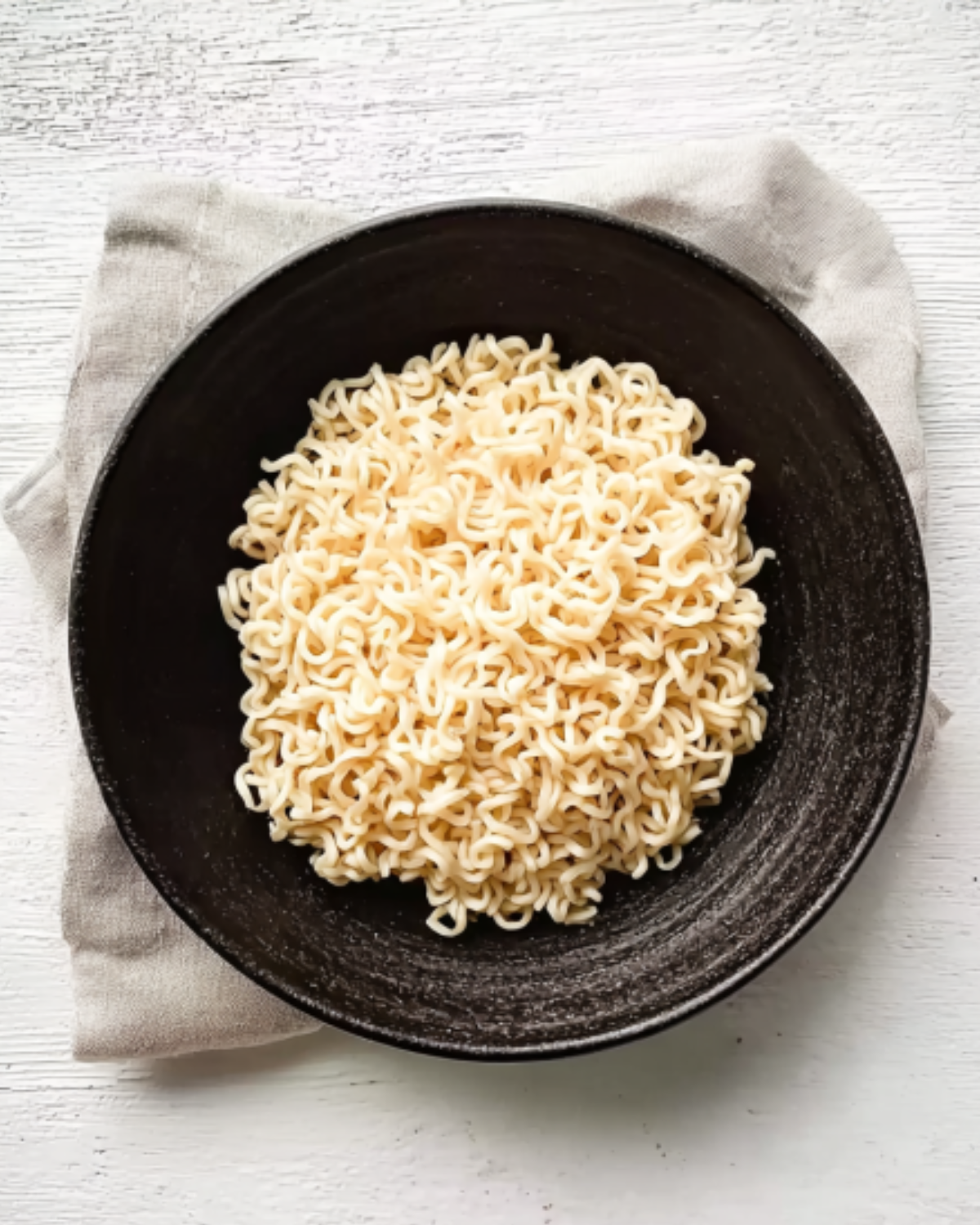 buldak-ramen-recipe-cooked-noodles-in-bowl Cooked instant noodles served in a dark bowl for buldak ramen recipe