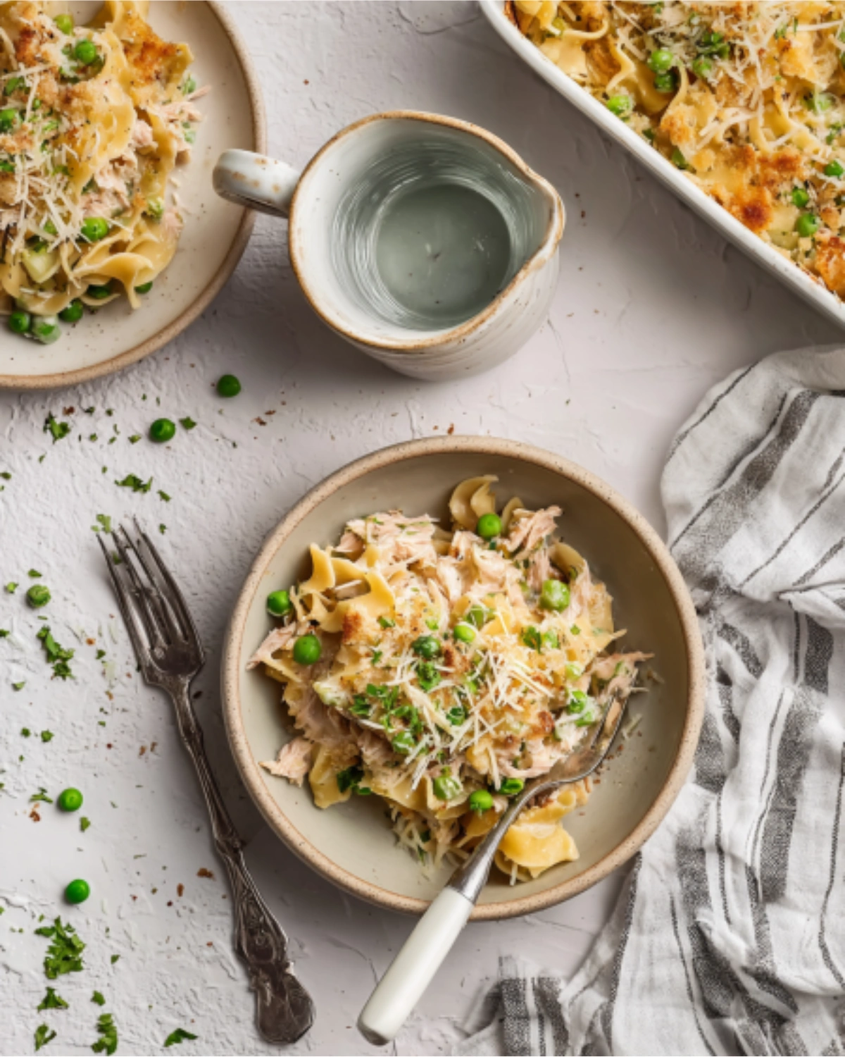 4-ingredient-tuna-casserole-recipe Bowl of creamy 4 ingredient tuna casserole topped with peas and shredded cheese