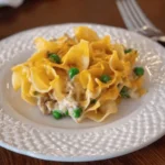 Single serving of 4 ingredient tuna casserole with peas and creamy noodles on a white plate