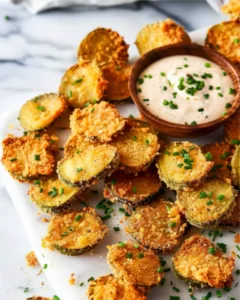 Close-up of crispy Air Fryer Fried Pickles served with creamy dipping sauce and chopped chives