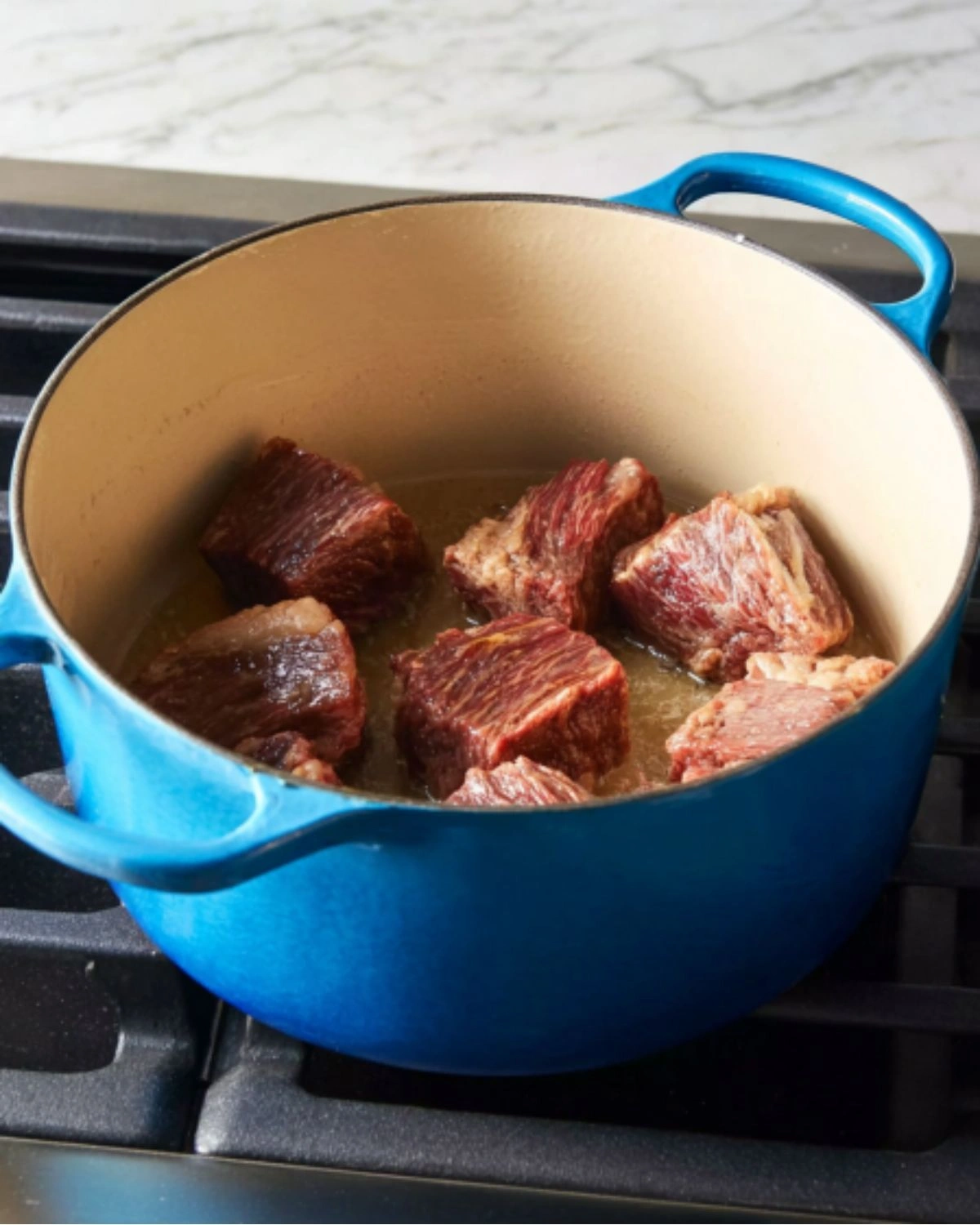 beef-stew-with-vegetables-and-potatoes-searing-beef Beef chunks searing in a Dutch oven for beef stew with vegetables and potatoes