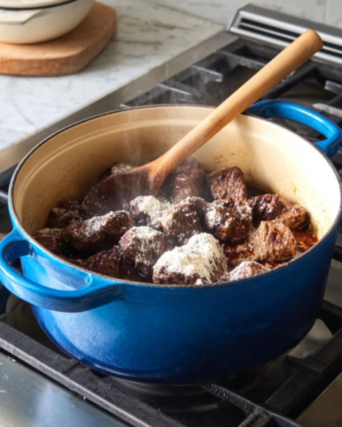 beef-stew-with-vegetables-and-potatoes-flouring-browned-beef Flour-dusted browned beef cooking in a Dutch oven for beef stew with vegetables and potatoes