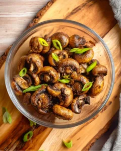 Air Fryer Mushrooms served in a glass bowl garnished with fresh green onions
