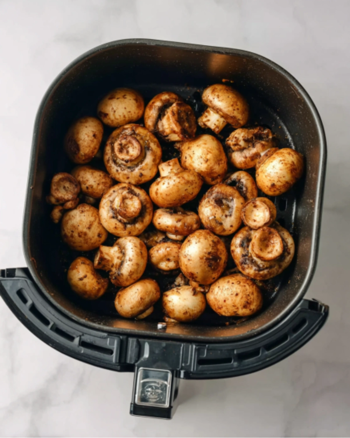 air-fryer-mushrooms-in-basket Air Fryer Mushrooms placed in an air fryer basket, seasoned and ready to cook