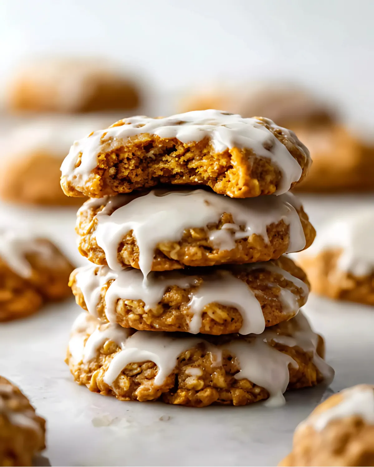 pumpkin-oatmeal-cookies-stacked-drizzled-glaze Stack of soft pumpkin oatmeal cookies with icing drizzle on top