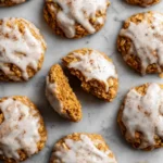 Top view of pumpkin oatmeal cookies topped with vanilla glaze and sprinkled with spice