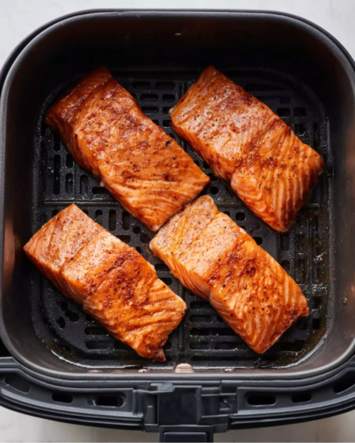 air-fryer-salmon-recipe-step-3-cooking-in-airfryer Air Fryer Salmon Recipe step 3 showing marinated salmon fillets cooking in the air fryer basket