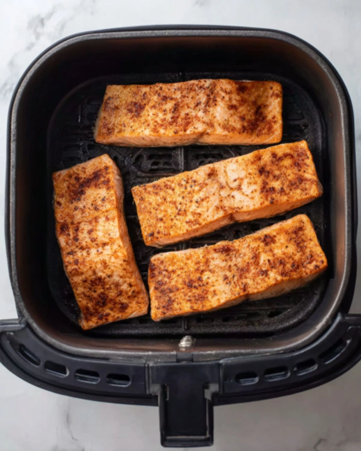 air-fryer-salmon-recipe-step-4-cooked-fillets-in-airfryer Air Fryer Salmon Recipe step 4 showing perfectly cooked salmon fillets inside the air fryer basket