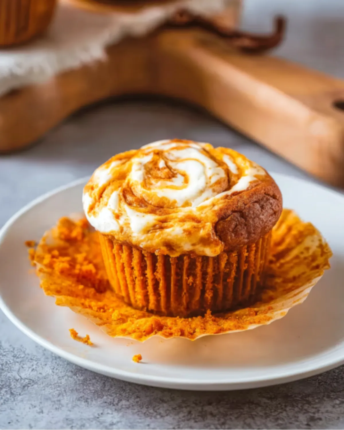 pumpkin-muffins-with-cheesecake-swirl Pumpkin muffins with cheesecake swirl on a white plate with the wrapper peeled back