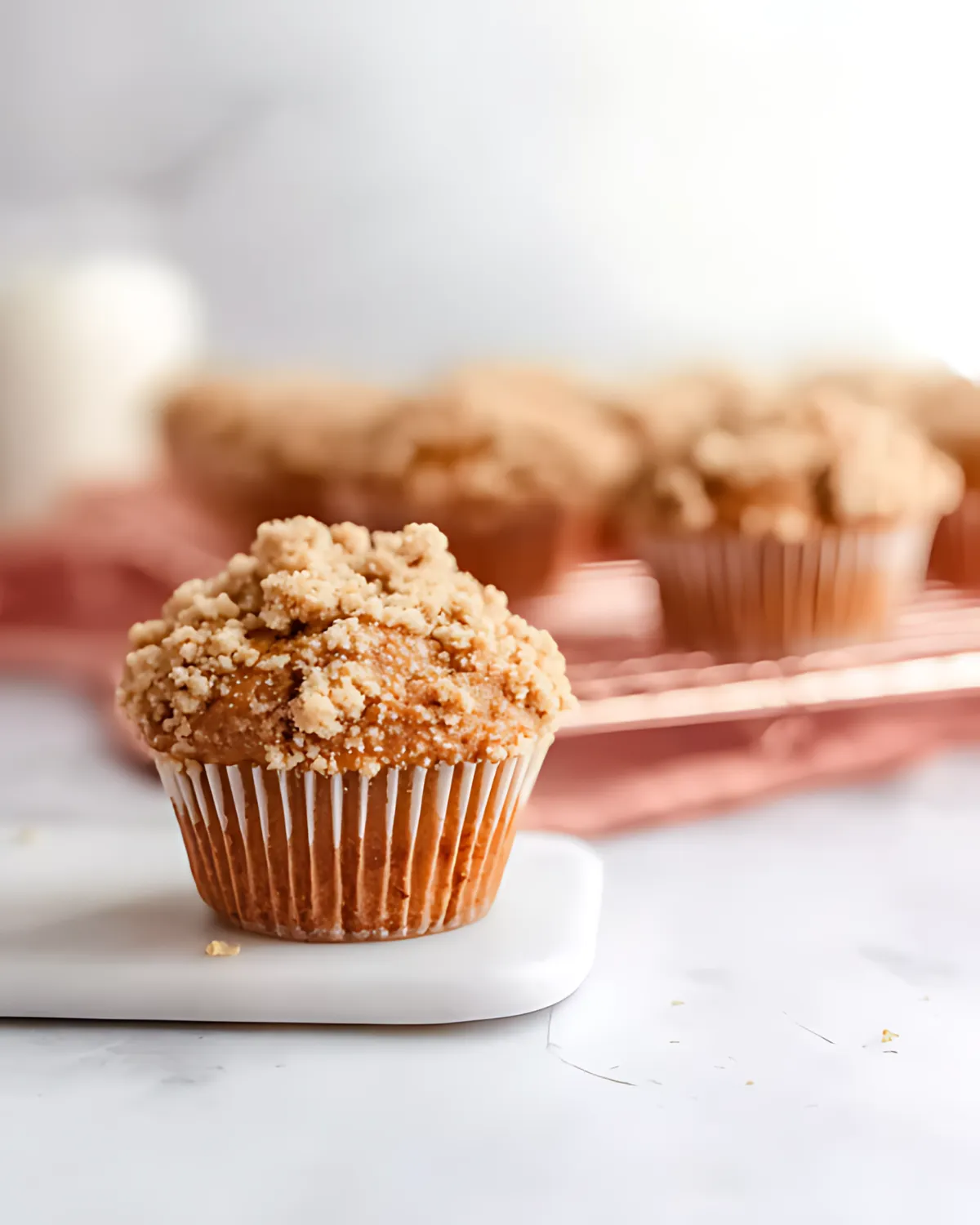 spiced-pumpkin-muffins-with-streusel-topping Single spiced pumpkin muffin with streusel topping on white marble background