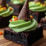 Moist Witch Hat Brownies with green frosting and tilted chocolate cone hats, decorated with Halloween candy sprinkles.