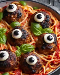 Close-up of spooky spaghetti and meatballs with black olives styled like eyeballs for Halloween