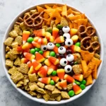 Top view of Halloween Harvest Snack Mix featuring candy corn, pretzels, Chex cereal, green candies, and candy eyeballs