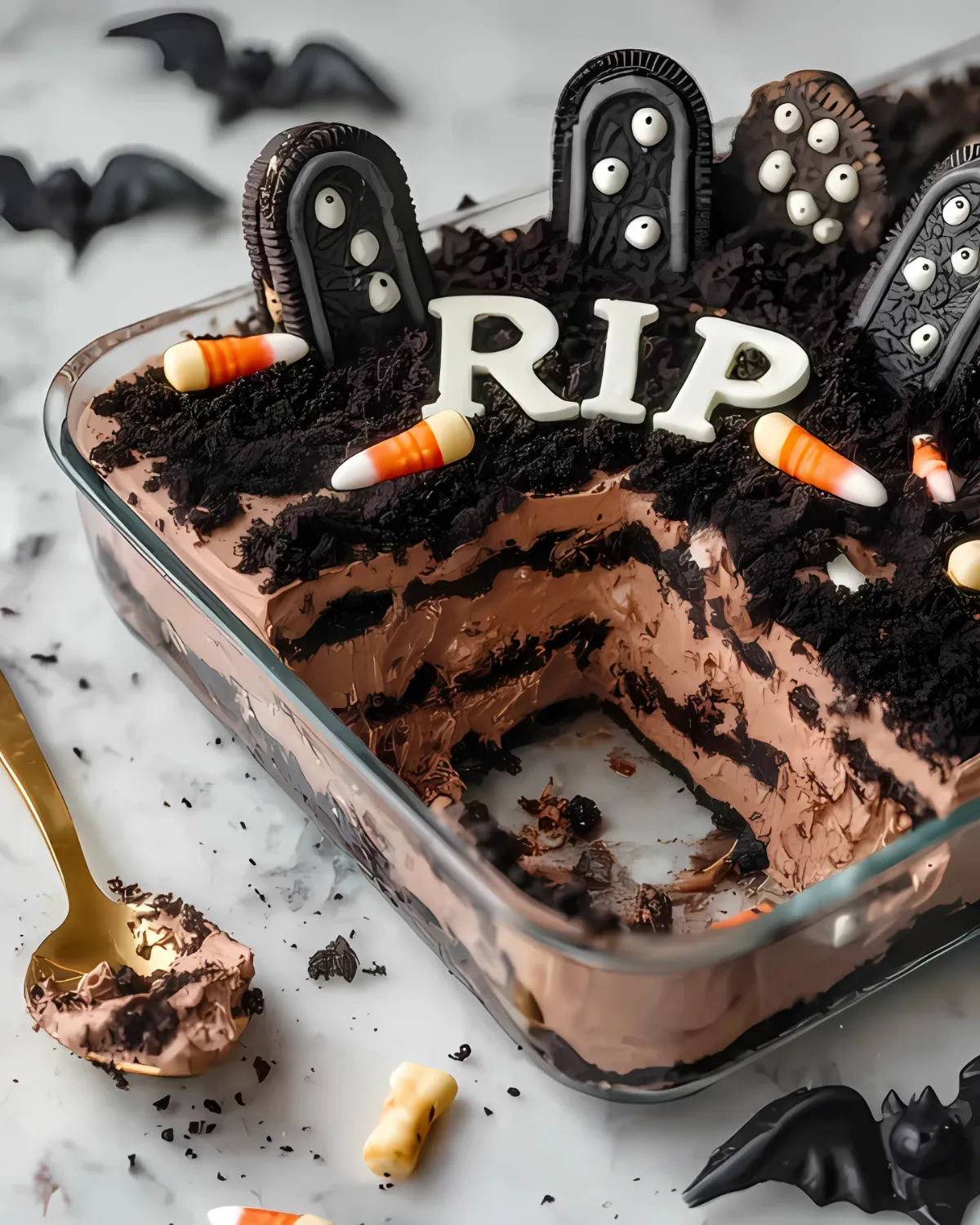 Graveyard Chocolate Cake with spooky Oreo tombstones, candy eyeballs, and layers of chocolate mousse and cookie crumbs