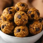 Pumpkin Energy Balls made with oats, peanut butter, chocolate chips, and fall spices in a white bowl