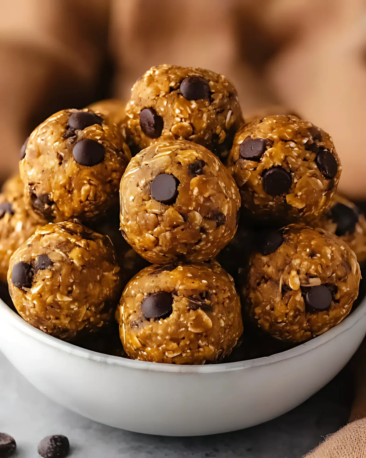 Pumpkin Energy Balls made with oats, peanut butter, chocolate chips, and fall spices in a white bowl