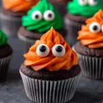 Close-up of chocolate monster cupcake with orange frosting and candy eyes – Monster Cupcakes Recipe