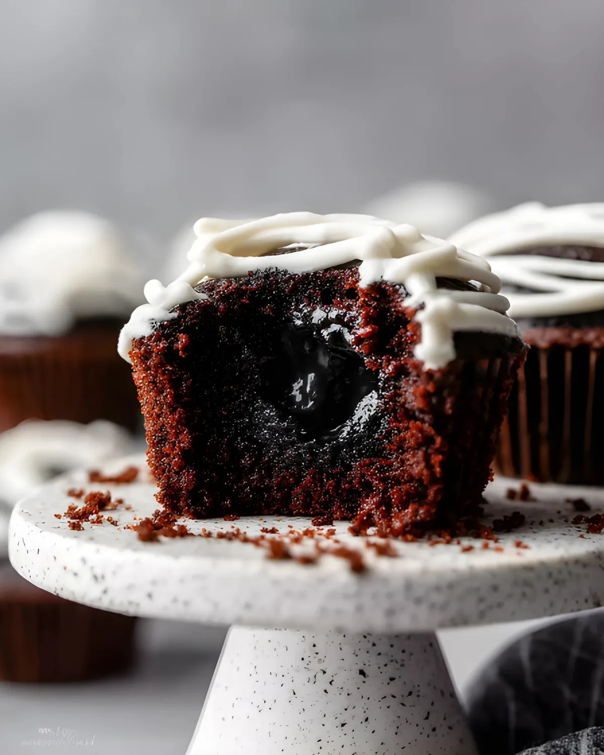 Close-up of Halloween Mummy Cupcake with a bite showing black gooey filling inside
