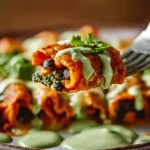 Close-up bite of Pumpkin Black Bean Enchiladas with creamy green sauce and fresh cilantro on a fork