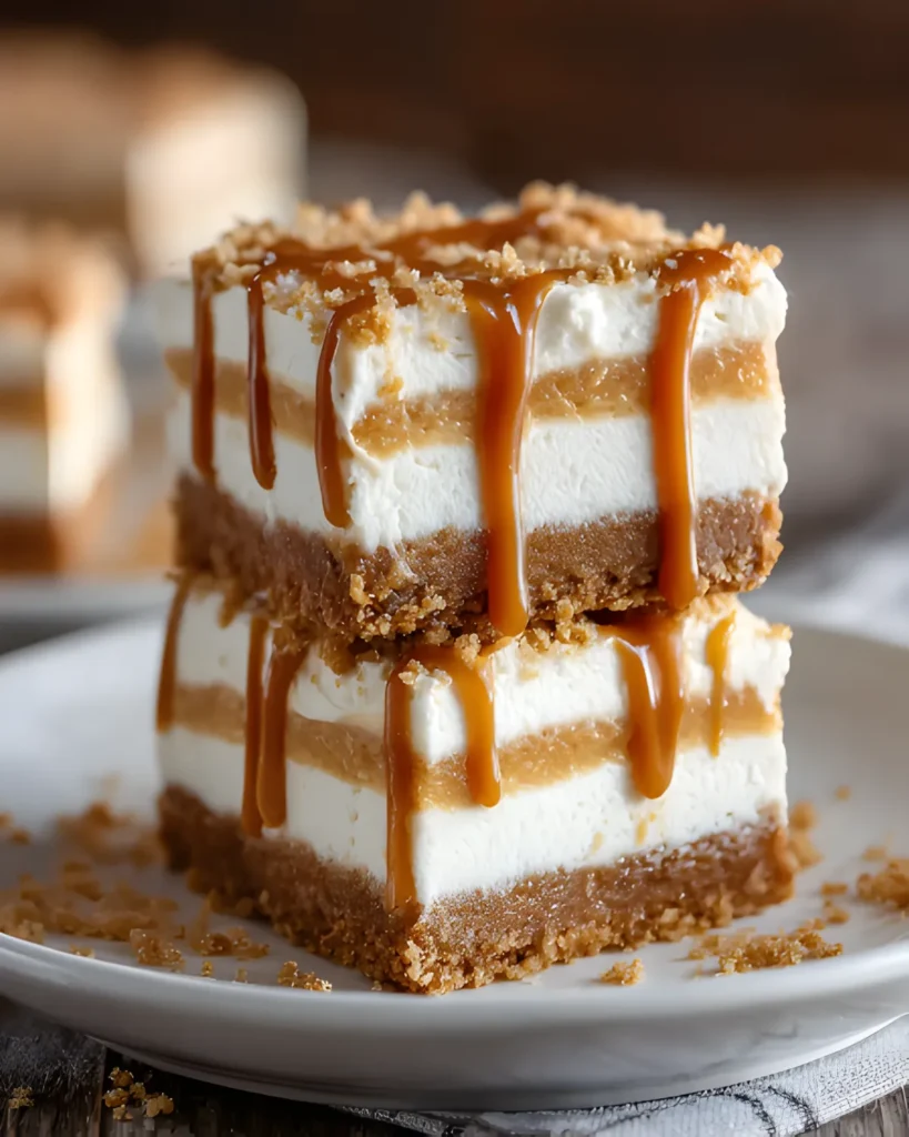 Close-up of rich and creamy pumpkin cheesecake bars topped with caramel drizzle on a plate