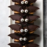 Bat Wing Chocolate Pretzel Mix with peanut butter and candy eyes on a white tray