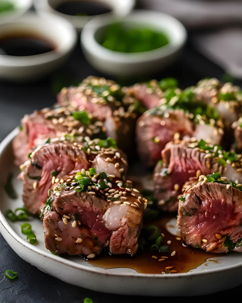 Sliced Beef Negimaki topped with sesame seeds and chopped green onions, served with teriyaki glaze.