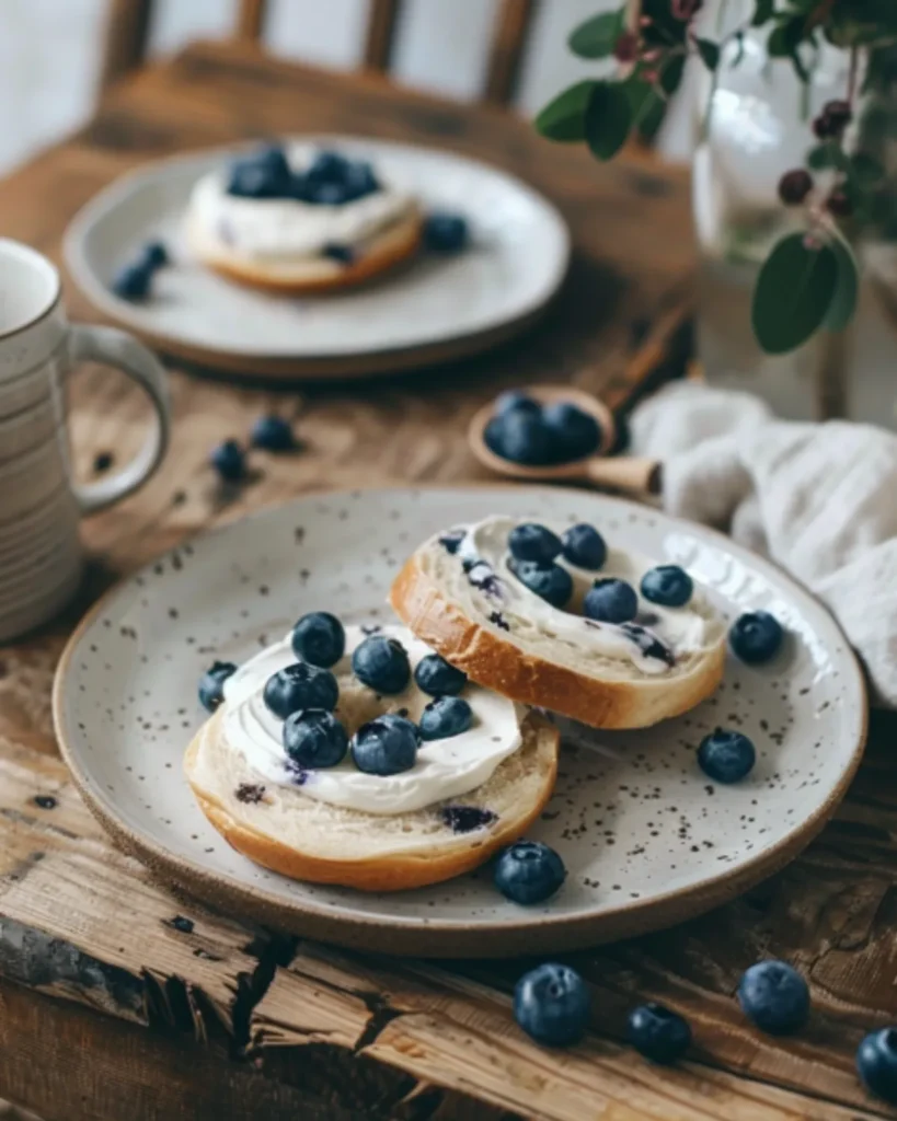 Blueberry Bagel Recipe served with cream cheese and fresh blueberries on a rustic wooden table