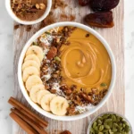 Pumpkin Pie Smoothie Bowl topped with banana, granola, coconut, and pumpkin seeds