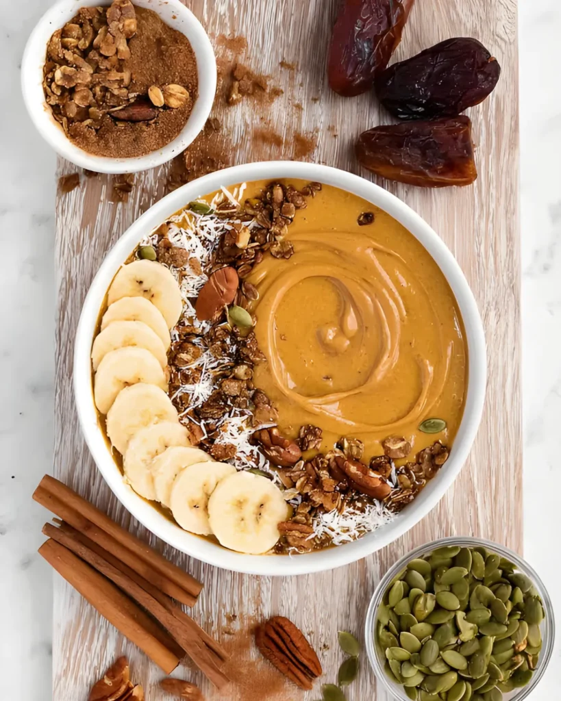Pumpkin Pie Smoothie Bowl topped with banana, granola, coconut, and pumpkin seeds