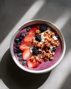 Berry Bliss Smoothie Bowl topped with fresh strawberries, blueberries, blackberries, crunchy granola, and coconut flakes.