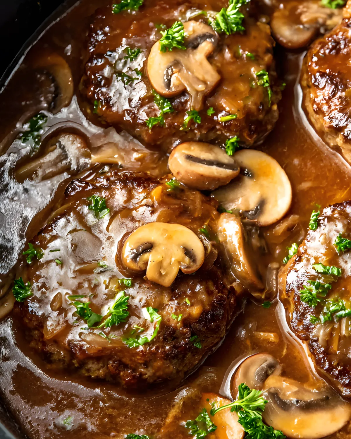 Tender Salisbury steak in gravy with mushrooms and parsley, slow-cooked to perfection.